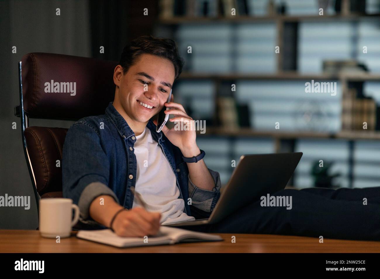 Young guy freelancer working from home office at night Stock Photo