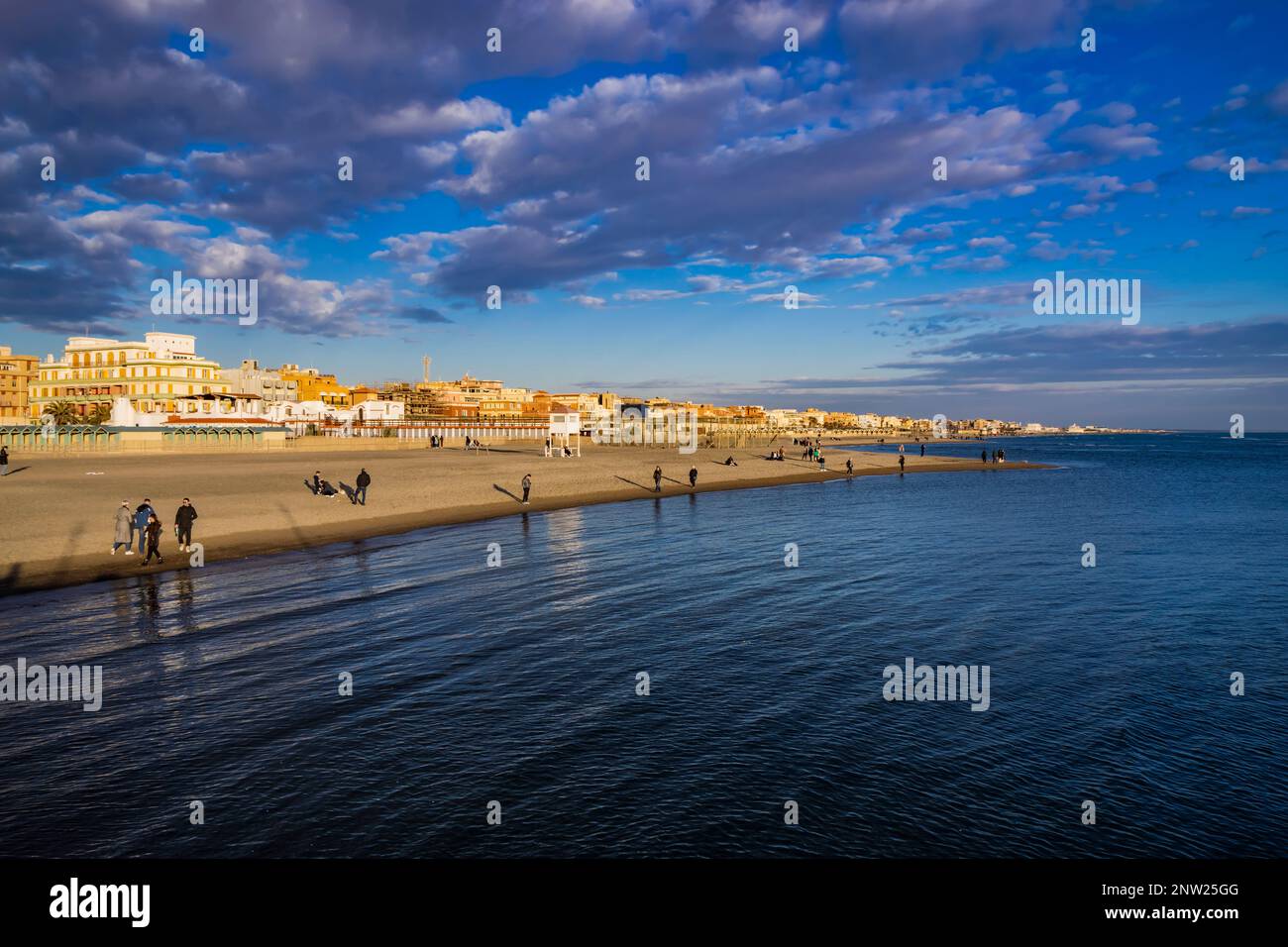 February 12, 2023 - Ostia, Rome, Italy. The sea of Ostia, on the Roman coast, on a winter Sunday. People enjoy the public holiday by walking on the be Stock Photo