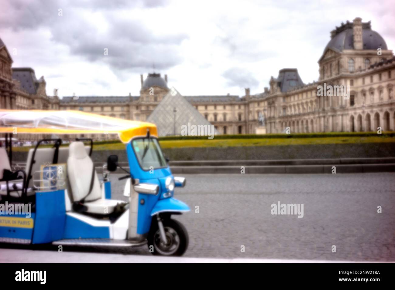 New, Age-defying, eye-catching, stand-out, high resolution, pinhole image ofTut-Tut tourist transport in front of the Louvre Pyramid and Museum, Paris Stock Photo