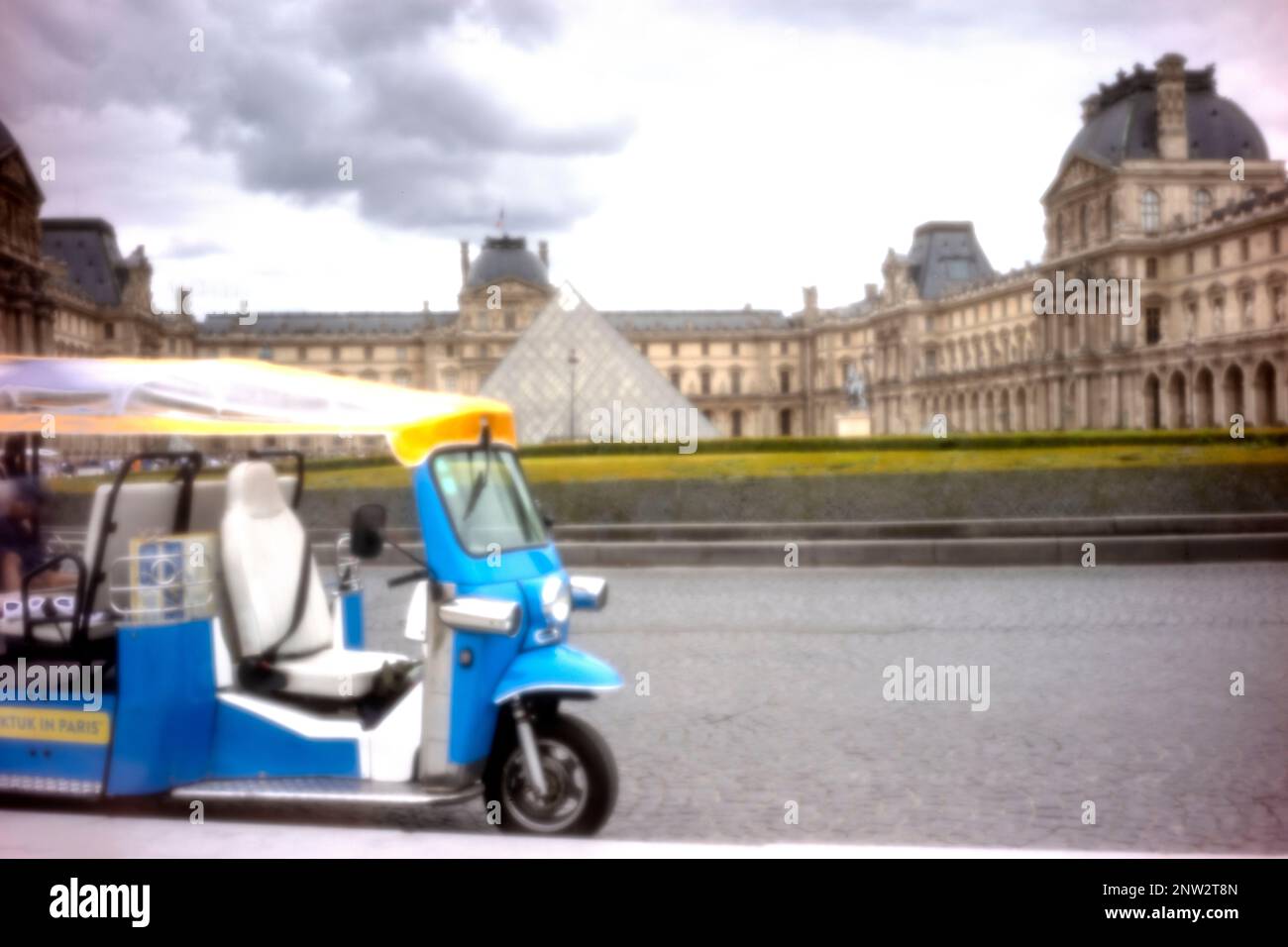 New, Age-defying, eye-catching, stand-out, high resolution, pinhole image ofTut-Tut tourist transport in front of the Louvre Pyramid and Museum, Paris Stock Photo