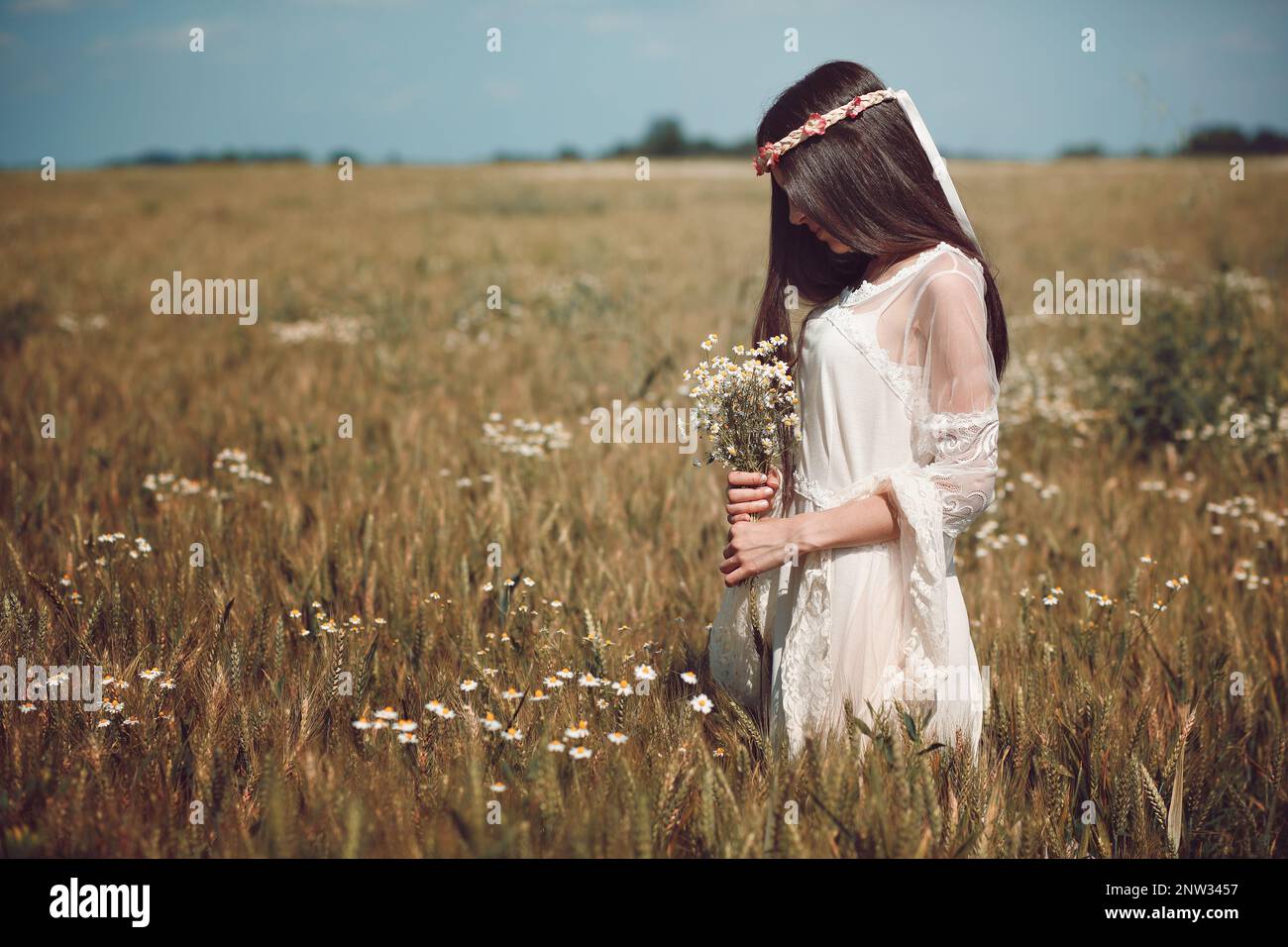 Beautiful sad maiden in summer field Stock Photo