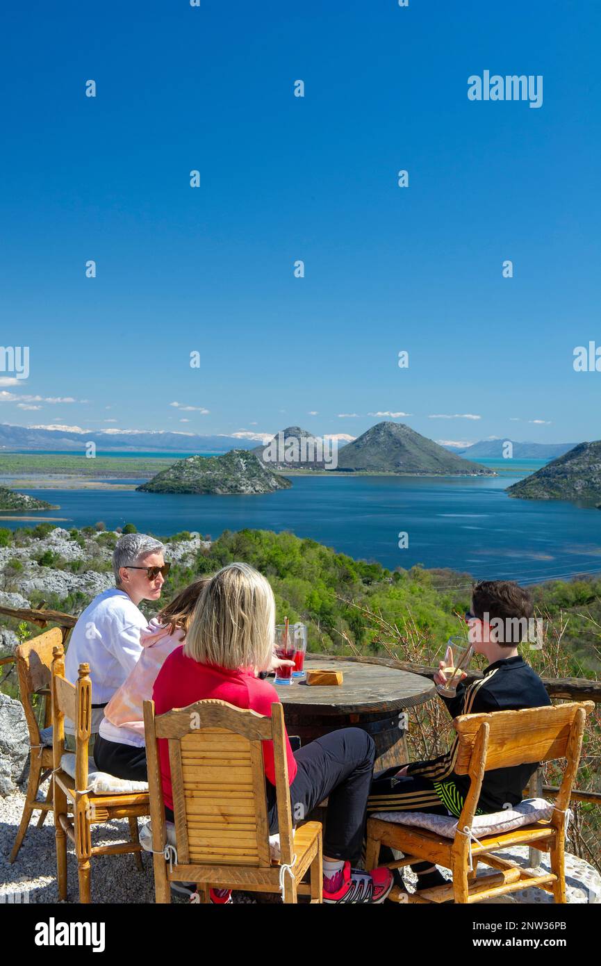Tourists enjoying the view over Lake Skadar from the Macalov brijeg (Macalov hill) cafe, Montenegro Stock Photo