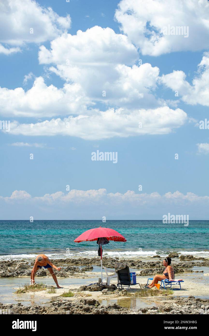 A couple of tourists at the Palude del Conte Beach near Punta Prosciutto, on the Ionian sea, Puglia, Italy Stock Photo