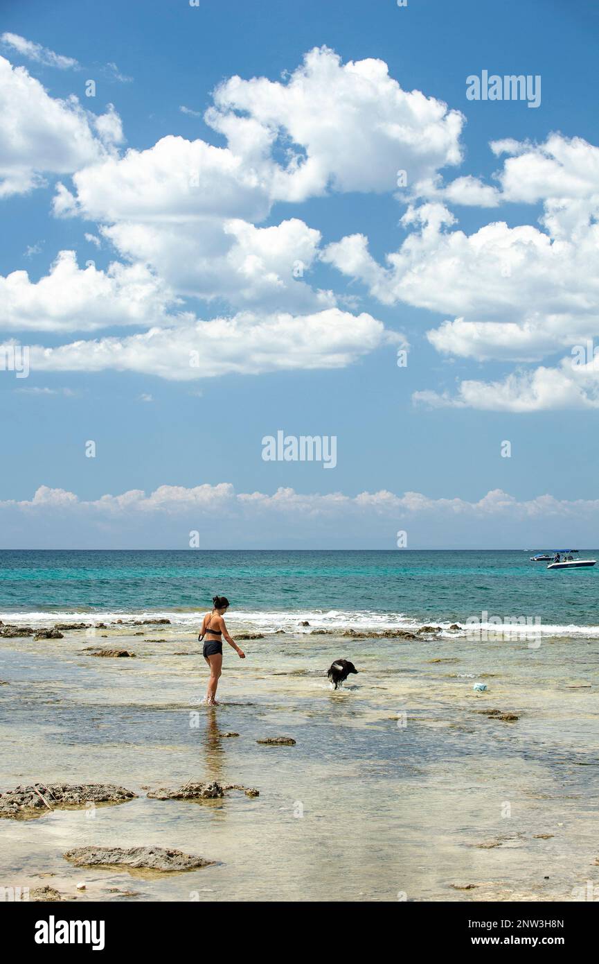 Woman with a dog at the Palude del Conte Beach near Punta Prosciutto, on the Ionian sea, Puglia, Italy Stock Photo