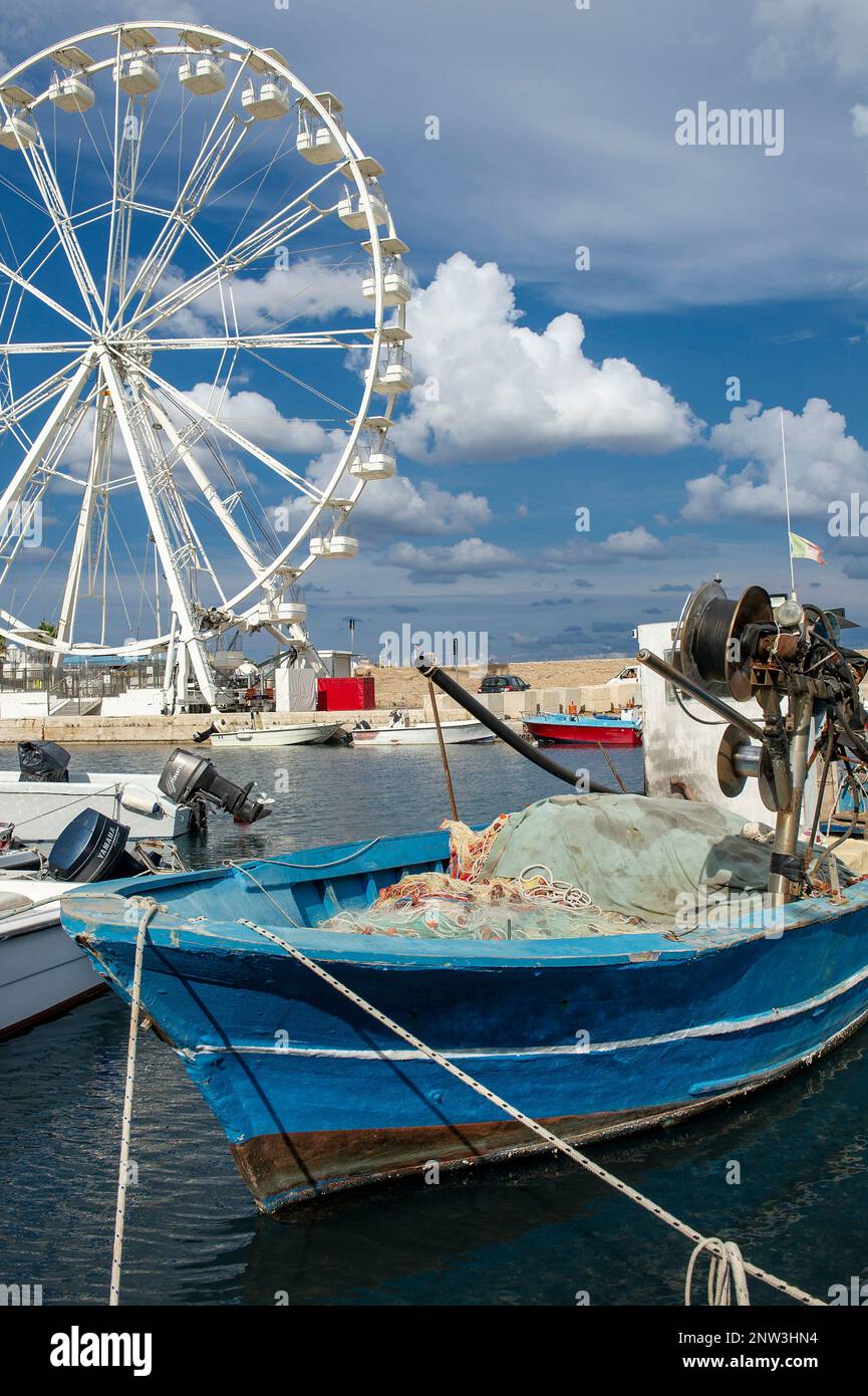 Detail of a fishing boat and a panoramic wheel in the small port in Campomarino, Puglia, Italy Stock Photo