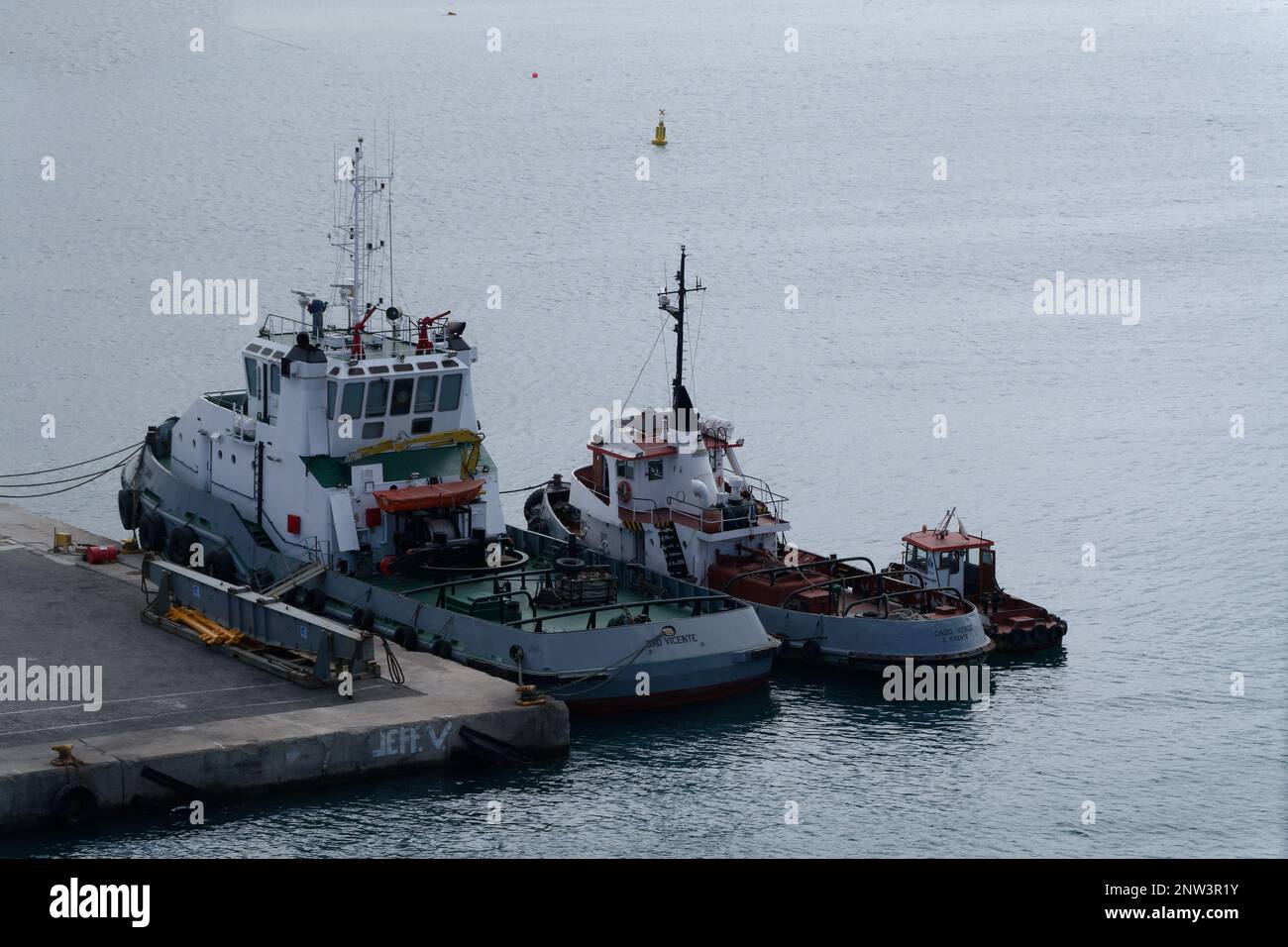 In Porto Grande Harbour Cape Verde Islands a family of different sized service vessels moored together - Large Tug, Small Tug and Pilot Boat Stock Photo