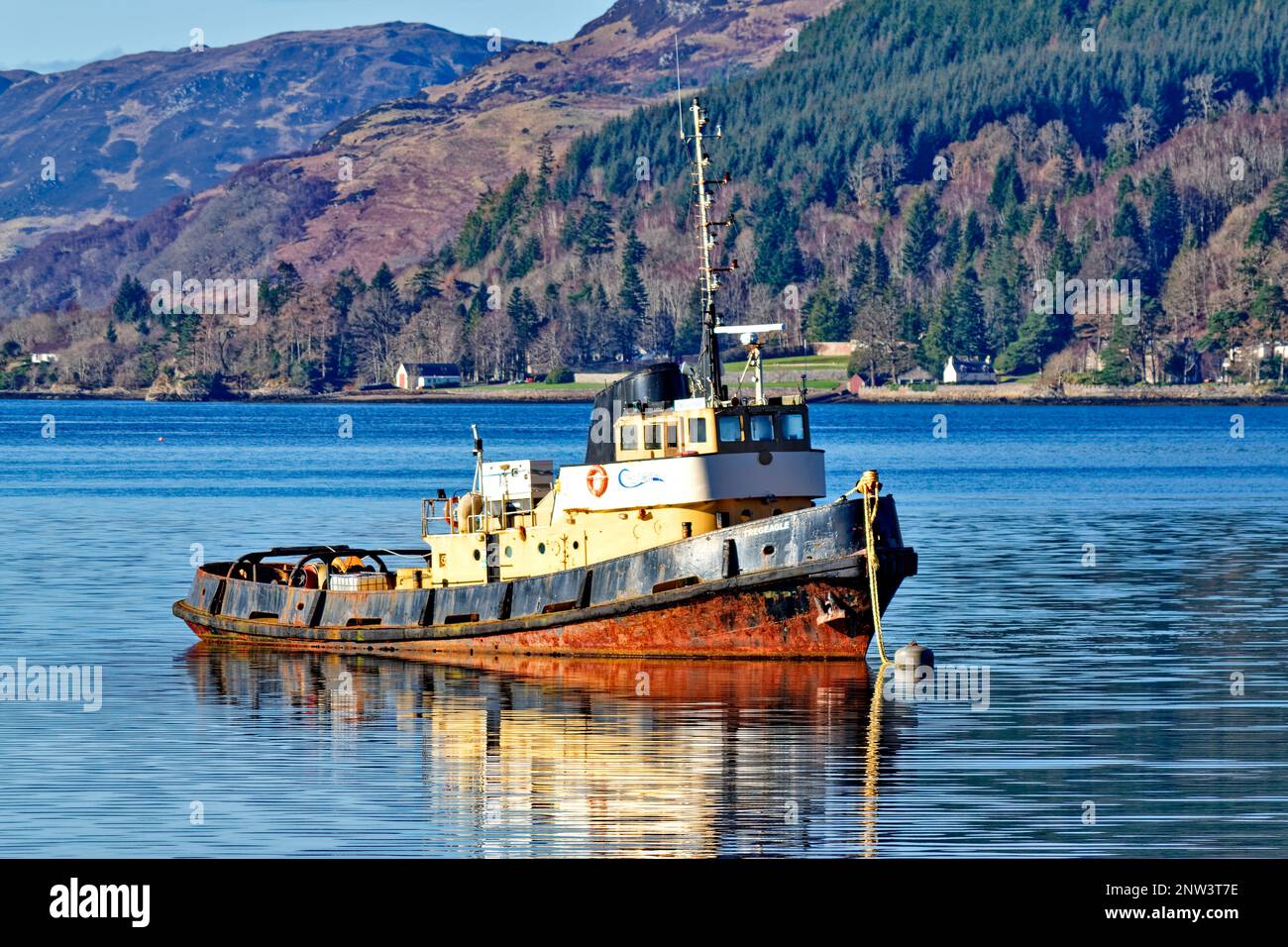 Loch Duich West Coast Scotland old tug boat Tregeagle reflected in the sea loch at high tide Stock Photo