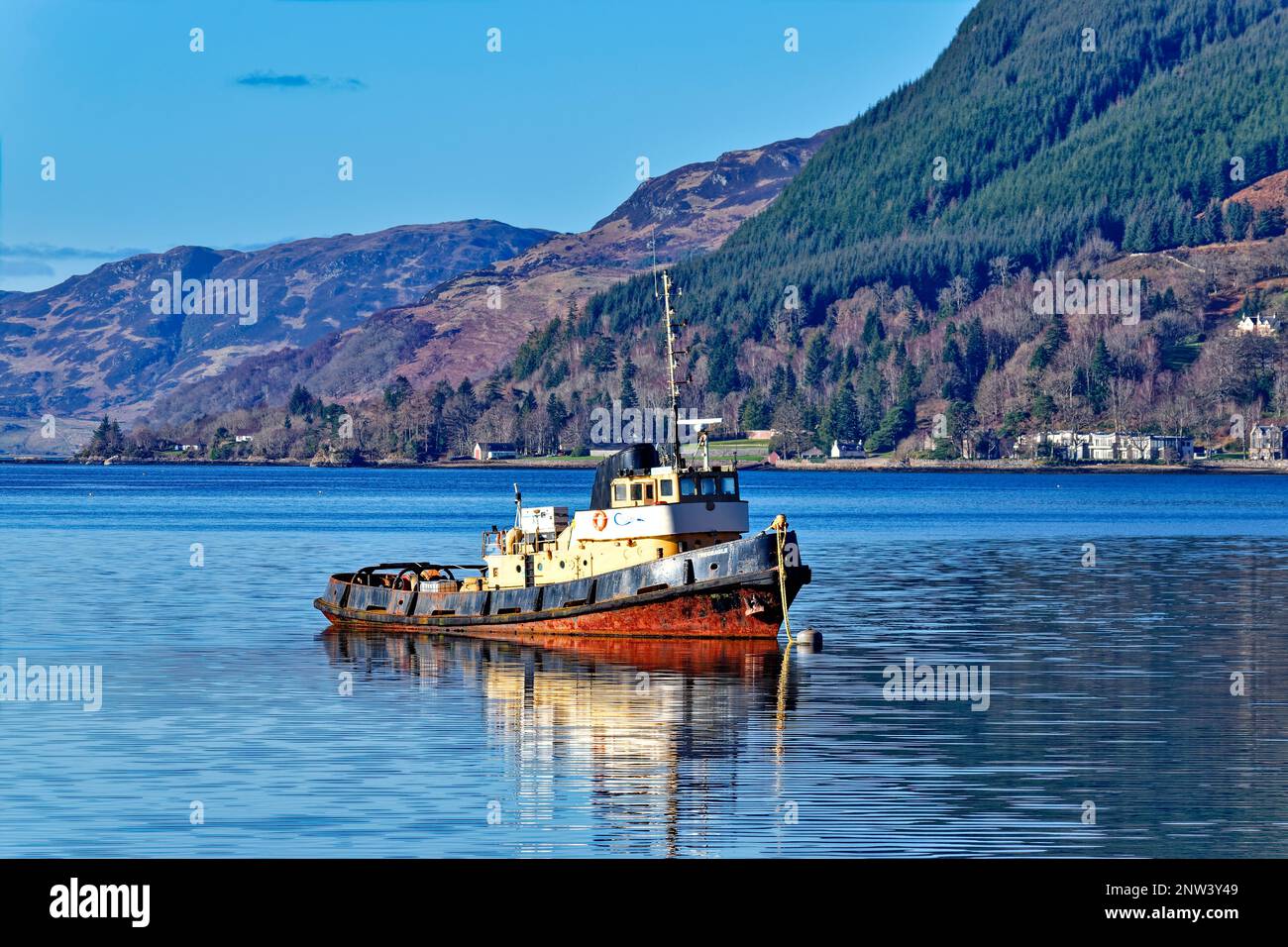 Loch Duich West Coast Scotland the old tug boat Tregeagle reflected in the sea loch at high tide Stock Photo