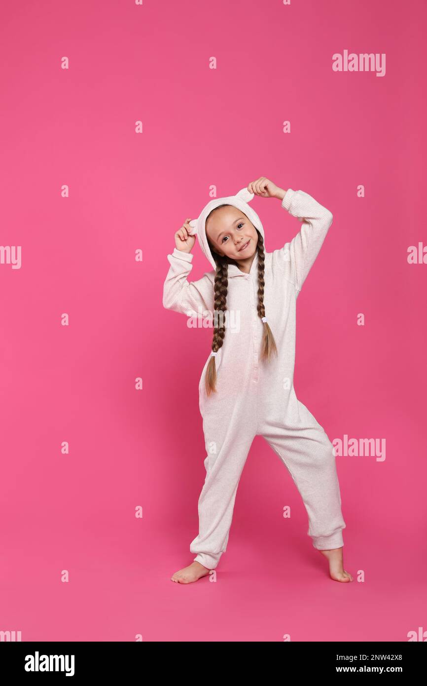 Cute girl wearing pajamas on pink background Stock Photo - Alamy