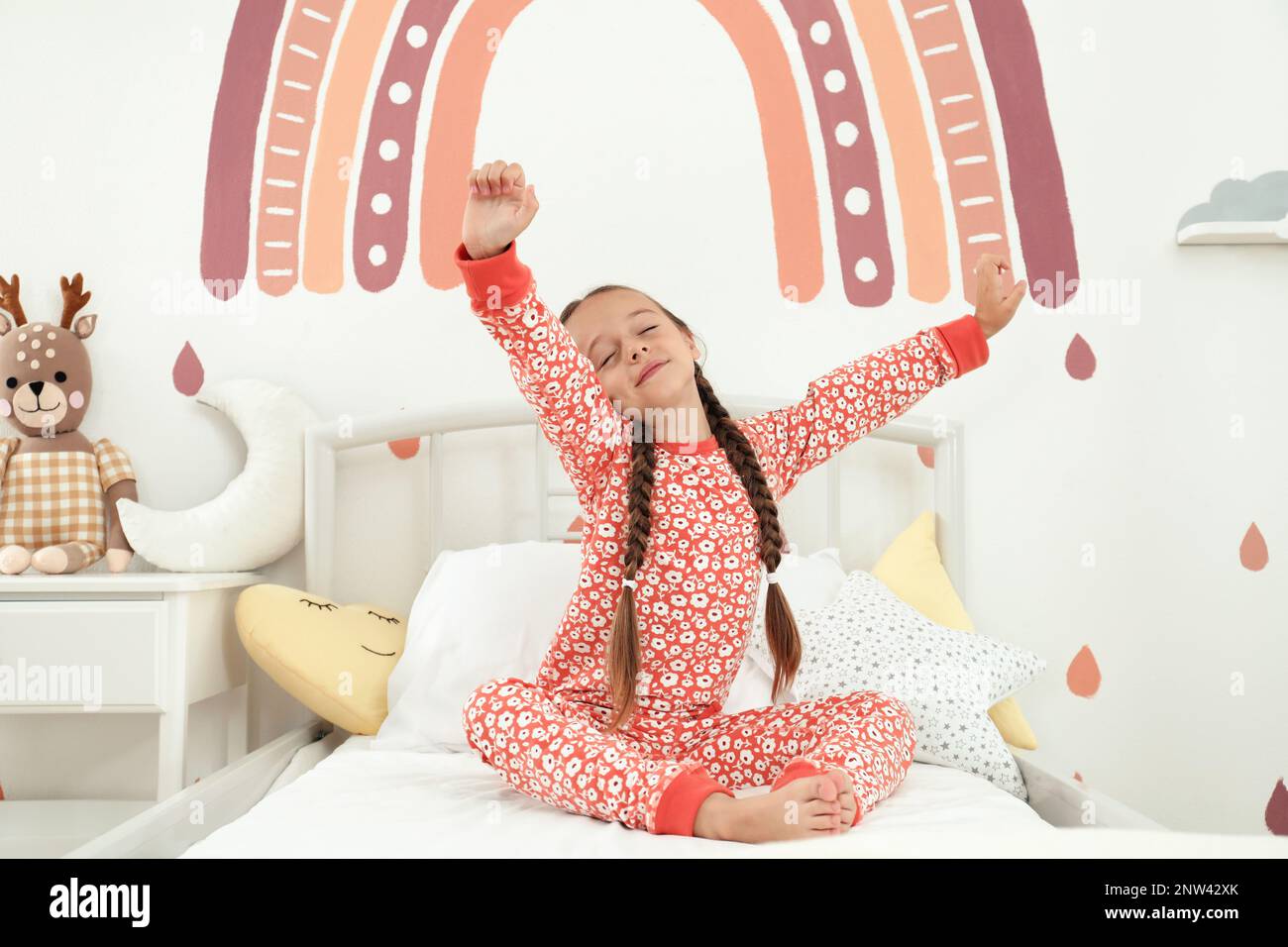 Sleepy girl in pajamas on bed at home Stock Photo - Alamy