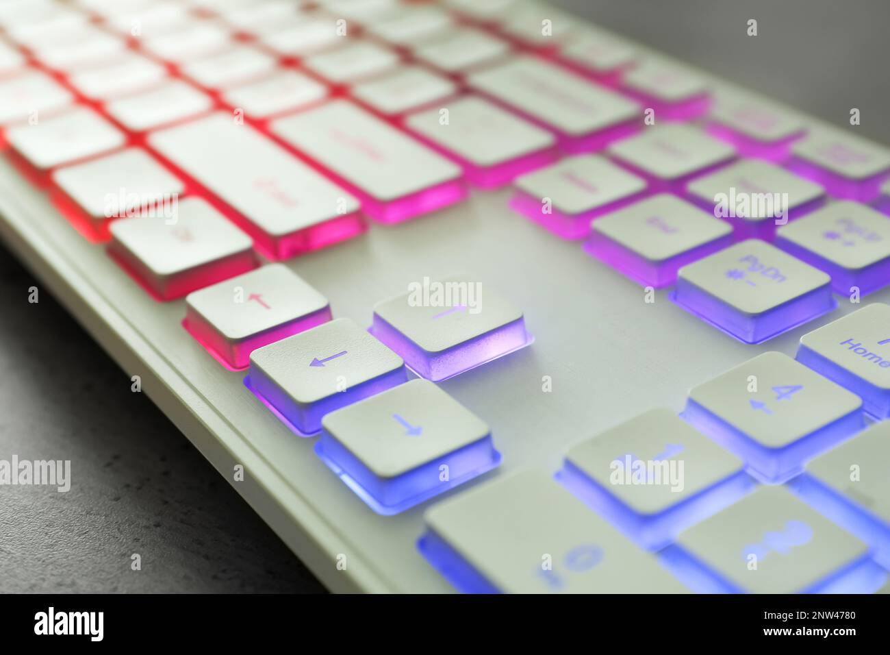 Modern keyboard with RGB lighting on grey table, closeup Stock Photo