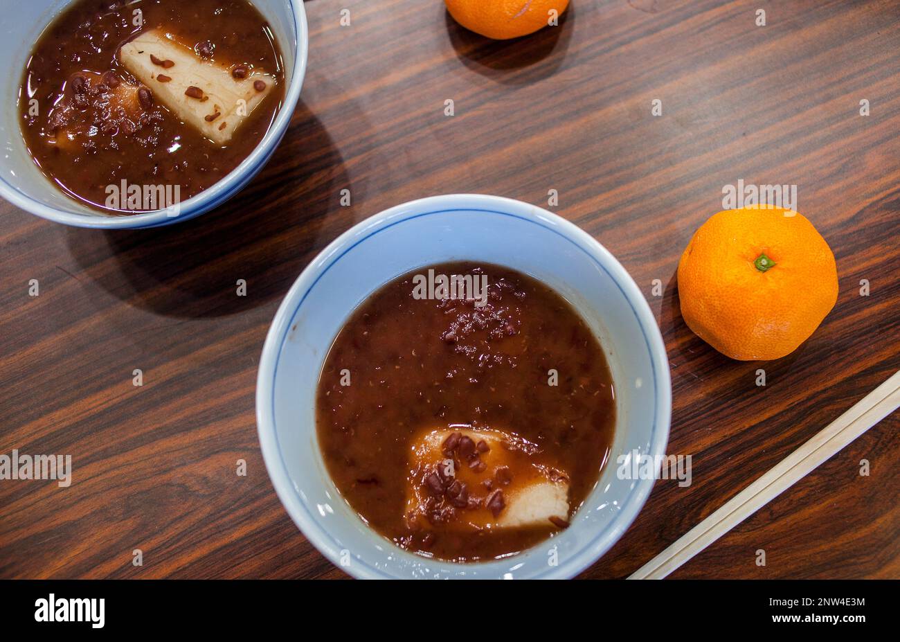 The ritual ends with the ingestion of a tamgerine and a Japanese rice cake called mochi, with sweet red bean soup, named Oshiruko. Ritual of kagami bi Stock Photo