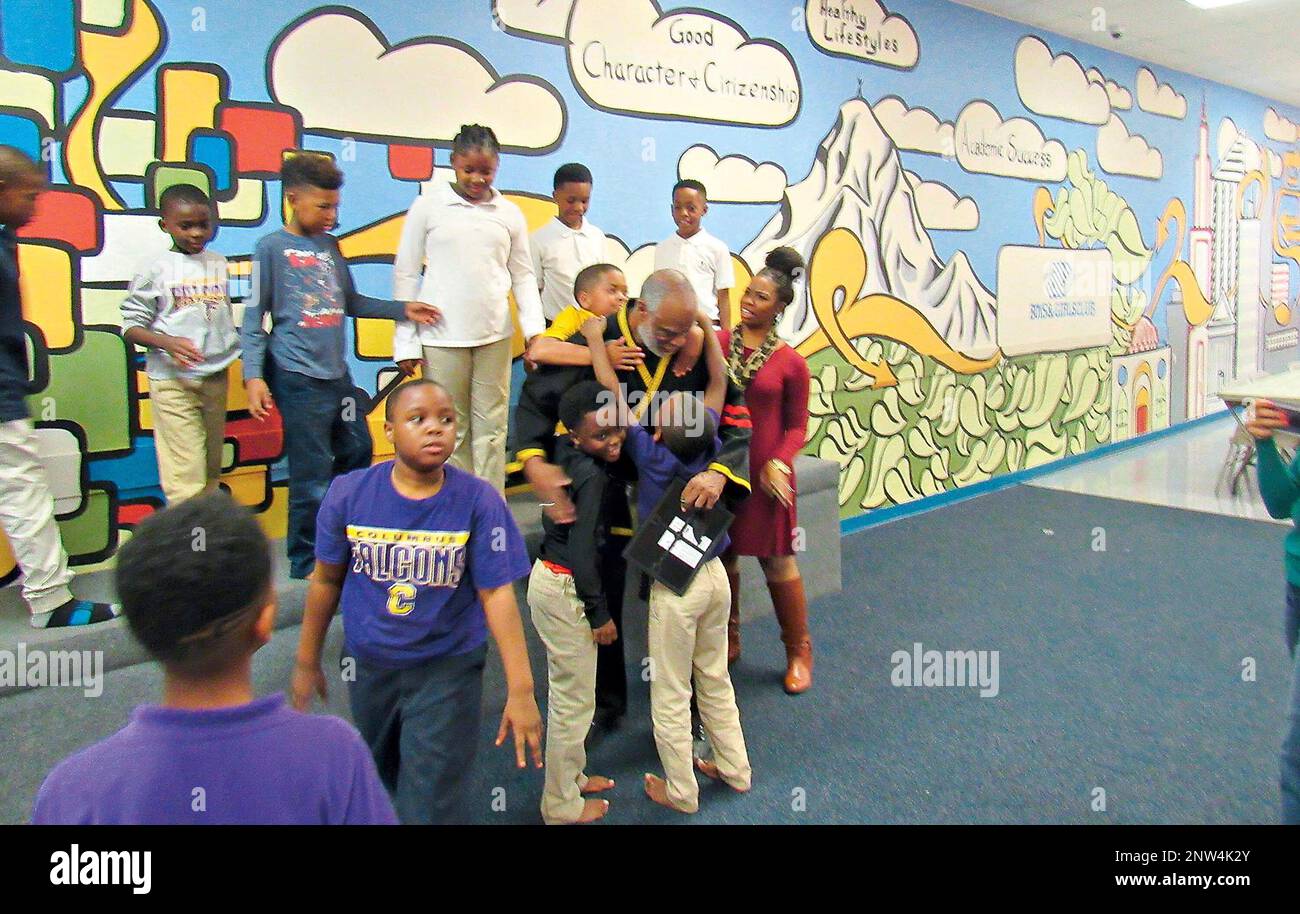 Taekwondo/boxing instructor Oliver Miller is smothered in hugs by his  students at the Columbus Boys and Girls Club Tuesday, Jan. 2, 2019 after  Miller was honored as the club's Mentor of the