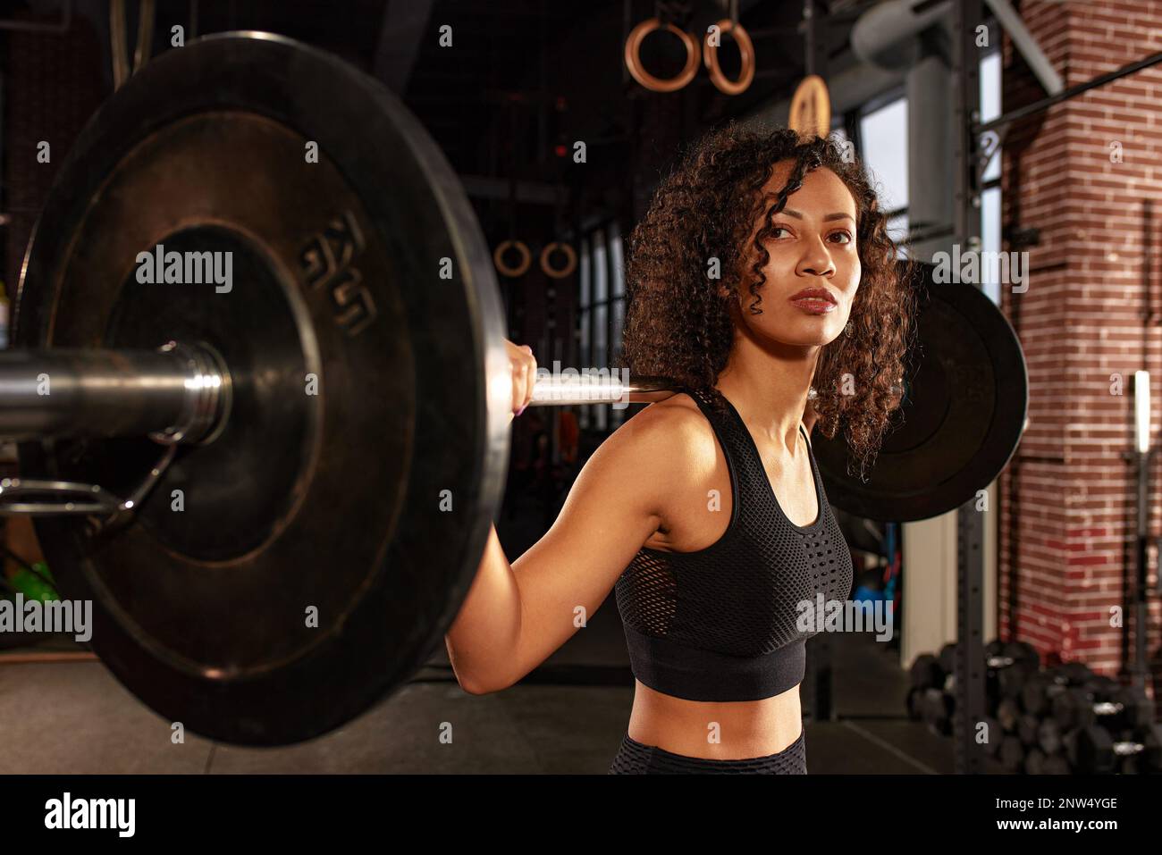 Young Pretty African American Sports Woman In Fitness Gym Lifting Up Empty Bar In Gym Doing Young Pretty African American Sports Woman In Fitness Gym Lifting Up Empty Bar In Gym Doing