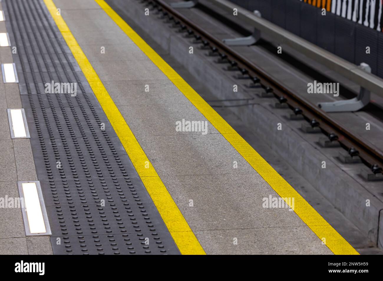 Yellow warning lines on a subway or train station platform. Safety systems in urban pedestrian traffic Stock Photo