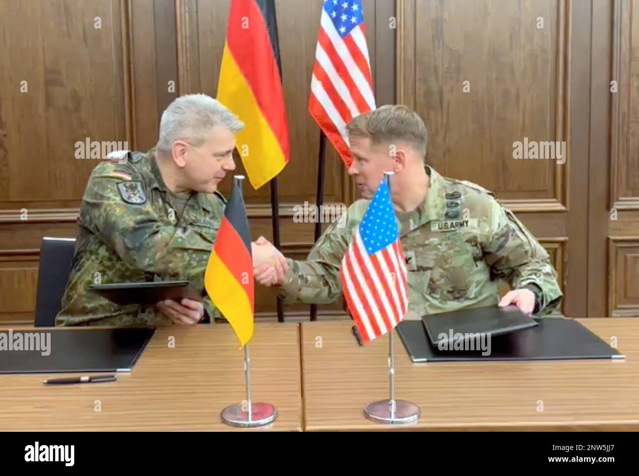 Col. Jon Dunn, Chief of International Affairs Division, G-3/5, Headquarters Department of the Army and Lt. Col. Christoph Kuhlmann, Director of the Bilateral-Multilateral, International Cooperation Branch of German Army Command  shake hands after signing a memorandum of agreement during the U.S.-German Army Staff Talks in Munich Jan. 24-26. The two Soldiers served as the heads of their respective delegations during the talks. Stock Photo