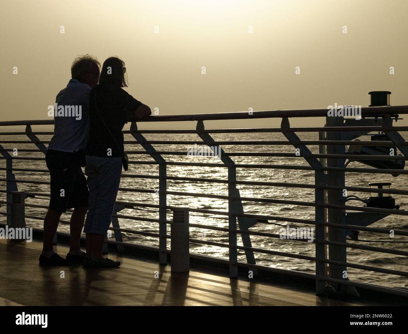 Sunset at Sea on the Atlantic Ocean. Sailing from the Cape Verde Islands to the Canary Islands on a cruise ship. A Couple standing together. Stock Photo