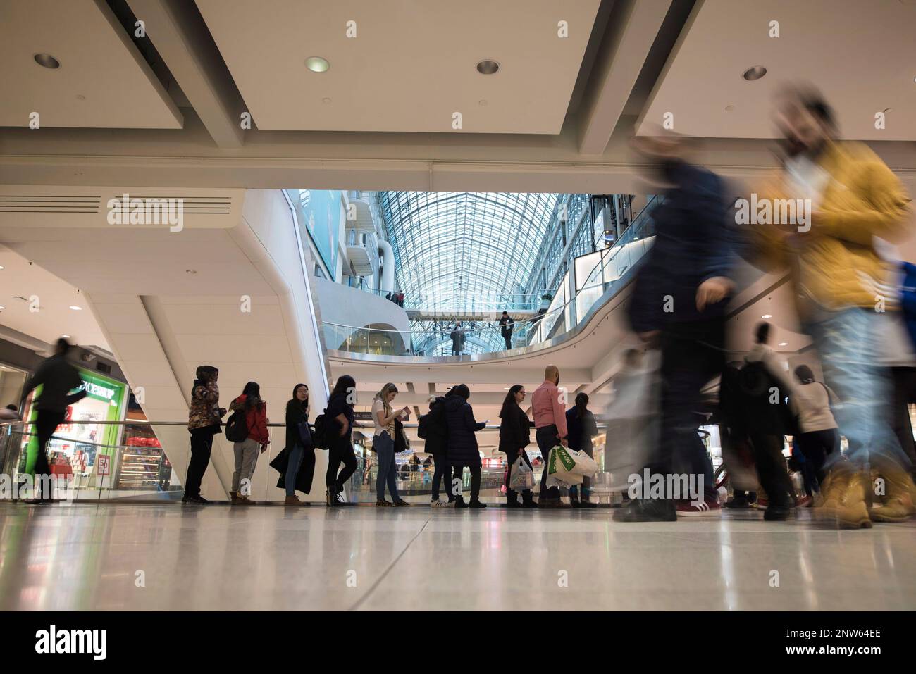 Shoppers wait in line to enter Pandora at Eaton Centre during