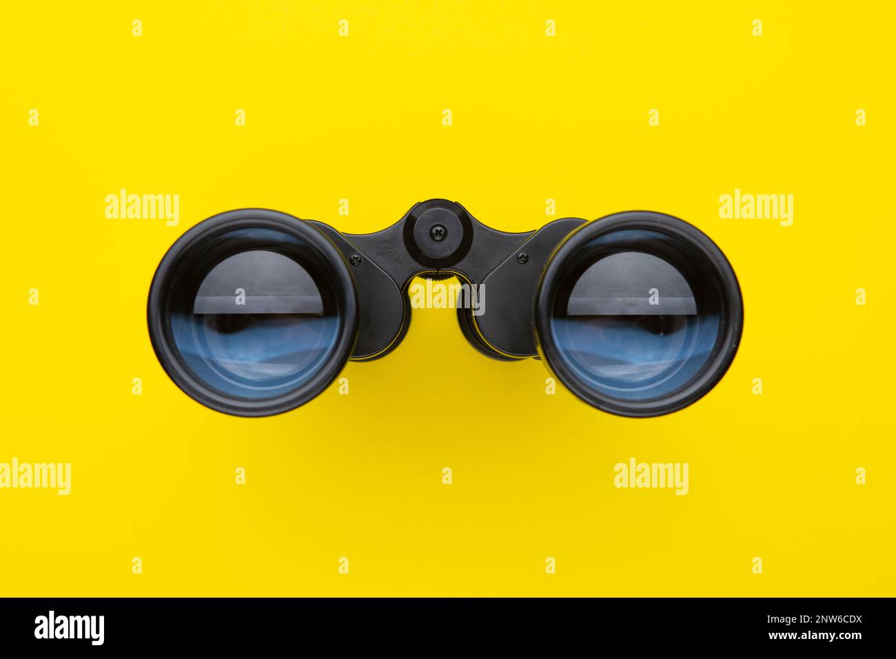Binoculars isolated on yellow background. Stock Photo