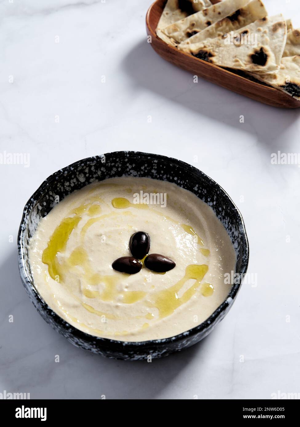 Taramasalata in the bowl with olive oil and black olive. Taramasalata is a Greek spread and meze made from tarama, the salted and cured roe of the cod Stock Photo