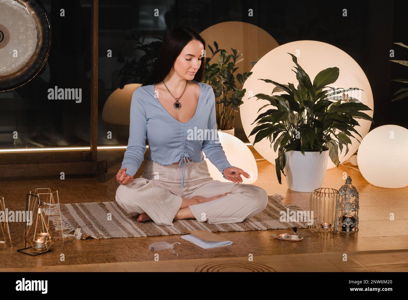 A young woman sitting in the Lotus position before the Game was playing and holding game cubes in her hand. Stock Photo