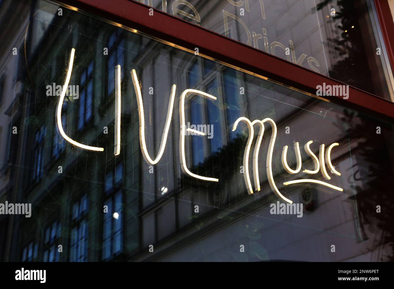 Neon sign saying "Live Music" in the front window of the music bar