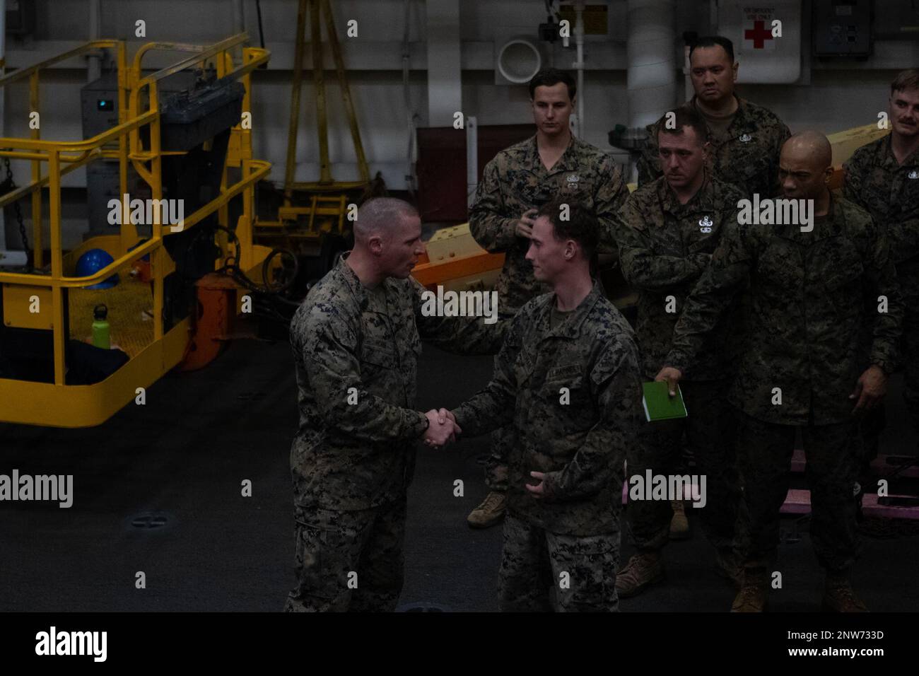 U.S. Marine Corps Sgt. Maj. James Horr, Sergeant Major of 26th Marine Expeditionary Unit (MEU), presents a challenge coin to Cpl. Bradley Hazelman, a light armored vehicle crewman assigned to Battalion Landing Team 1/6, while visiting the Marines and Sailors aboard the San Antonio-class amphibious transport dock ship USS Mesa Verde (LPD 19) while participating in Amphibious Squadron/MEU Integration Training (PMINT), Jan. 31, 2023. PMINT serves as an opportunity to strengthen integration between the 26th MEU and Amphibious Squadron Group 8’s and train to core mission essential tasks with capabi Stock Photo