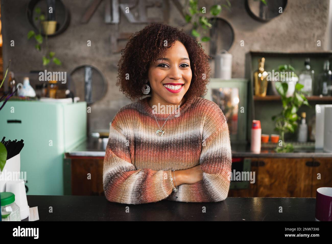 Portrait of smiling latin woman looking at camera smiling. Female in her kitchen. Stock Photo