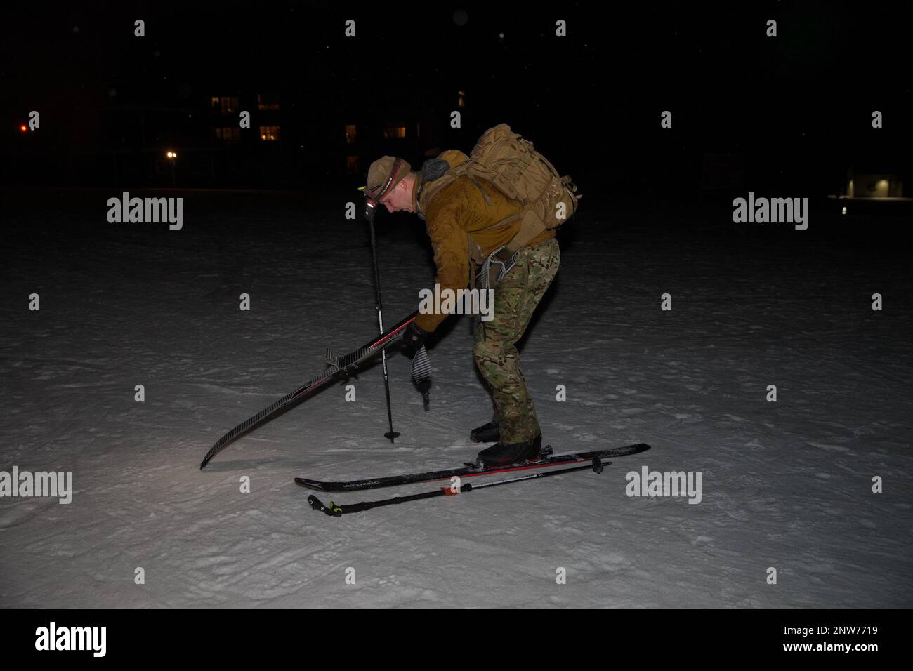 U.S. Army National Guard Soldiers of the 86th Infantry Brigade Combat Team (Mountain) and other units, prepare for Edelweiss Raid 2023 by ski training after dark in Jeffersonville, Vt., on Jan. 7, 2023. Soldiers spent the day alpine touring, or AT, through the Underhill and Stowe areas of Vermont’s highest peak, Mount Mansfield. After sunset, the competitors skied several ascents and descents of Morse Mountain at Smuggler’s Notch Resort. Here, the warrior applies skins to skies for improved climbing traction. The Edelweiss Raid is an international, military competition designed to test the alp Stock Photo