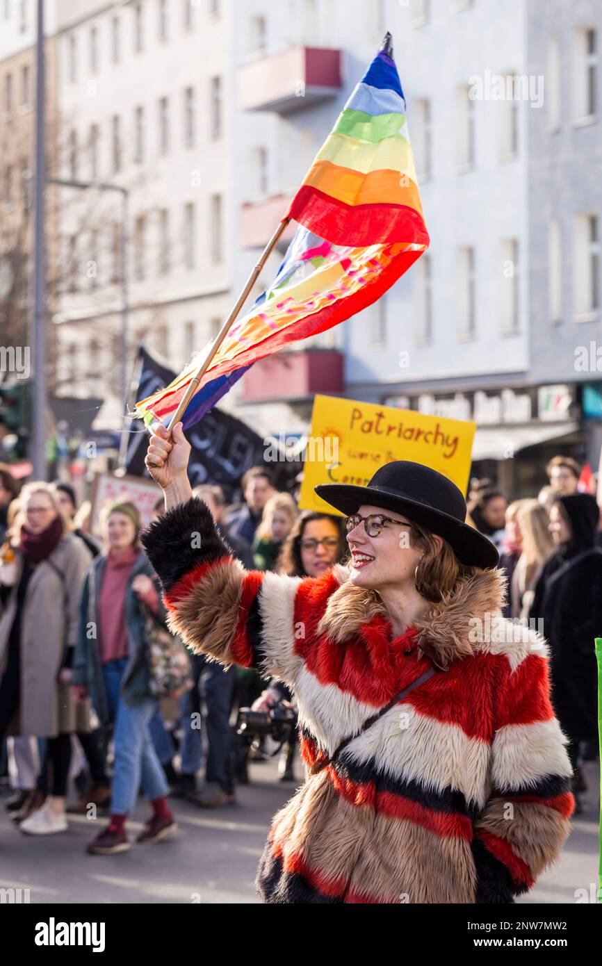 Berlin, Germany 3/8/2020 A young woman waves the rainbow LGBTQ+ flag during the International Women's Day 8M march protest Stock Photo