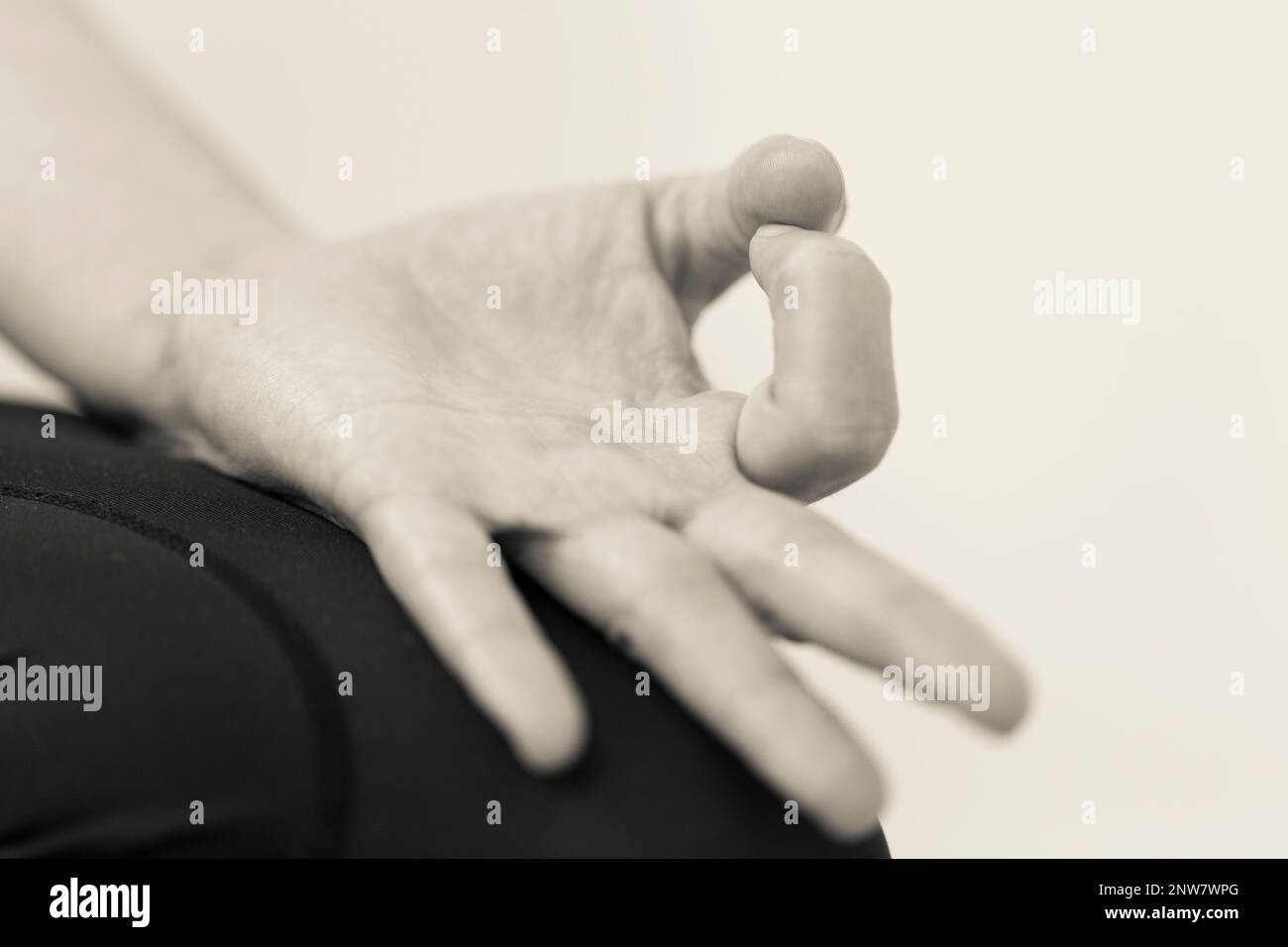 Black and white horizontal closeup of hand gesture or mudra with palm up, directing energy and maintaining focus during meditation. Stock Photo