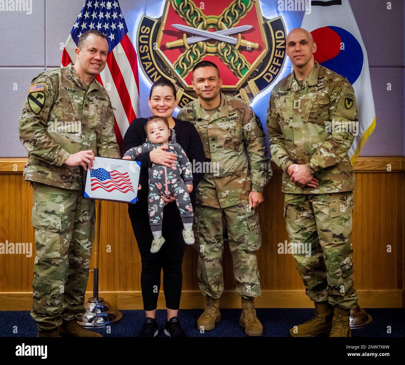 Col. Seth Graves, commander of USAG Humphreys (far-left), Veronica Lopez and    baby Martina Peña-Lopez (center-left), Sgt. Julian Peña (center-right) and Command Sgt. Maj. Monty Drummond, USAG Humphreys, senior enlisted adviser (far-right), take a group photo during Martina Peña-Lopez's U.S. naturalization ceremony. Stock Photo