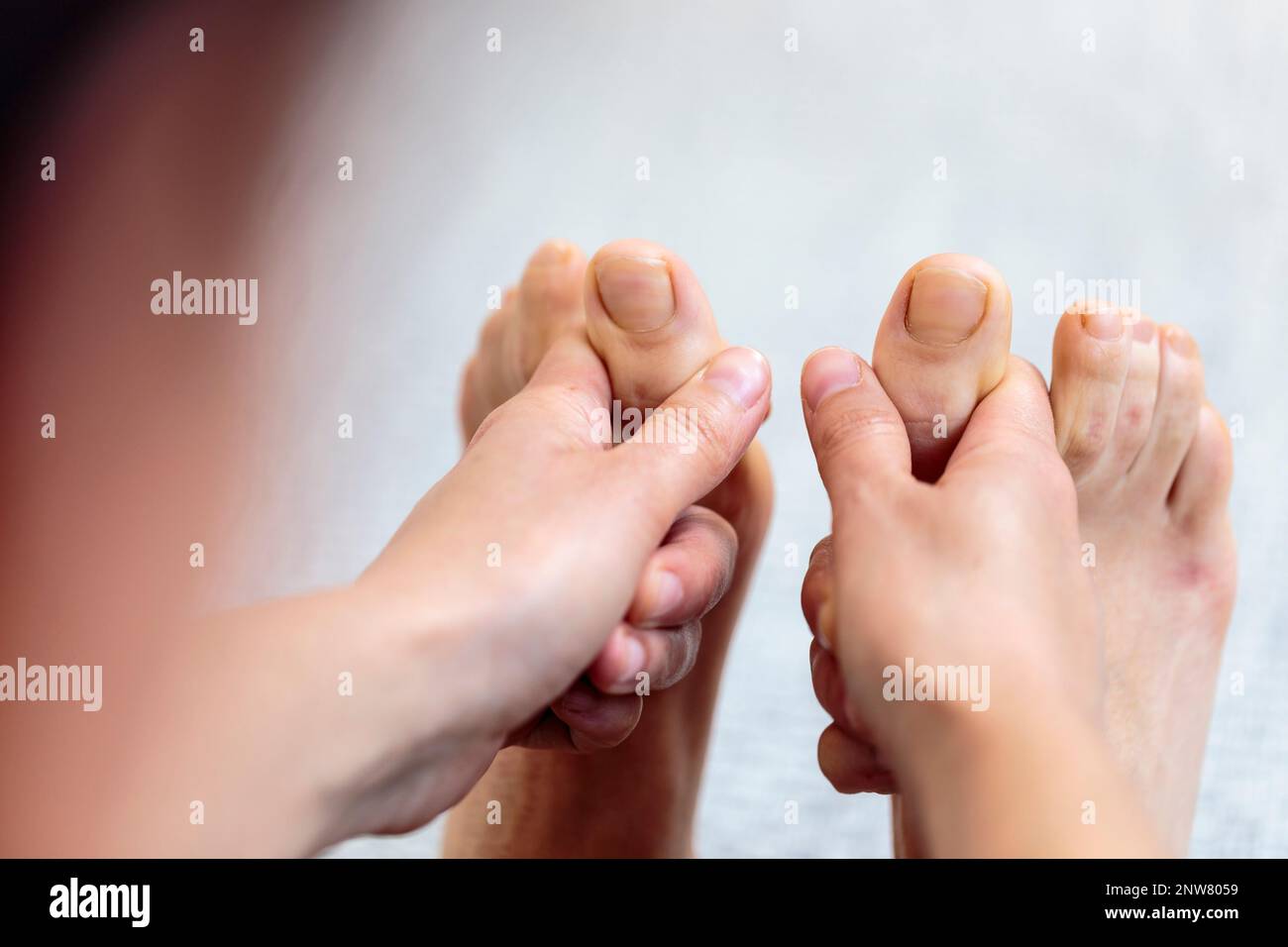 Yogini doing forward bending exercise on the floor, reaching foot and