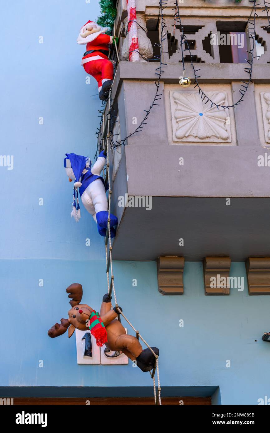 Father Christmas, the Snowman & Rudolf the red-nosed reindeer scale a rope ladder up to a balcony of a house in San Cristobal de La Laguna in Tenerfe. Stock Photo