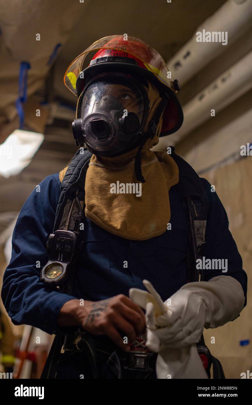 230106-N-JR318-1062 NORFOLK, Va. (Jan. 6, 2023) Aviation Electronics Technician 2nd Class Elijiah Mitchell, from Hollywood, Alabama, dons firefighting equipment during a simulated casualty aboard the Nimitz-class aircraft carrier USS Harry S. Truman (CVN 75), Jan. 6, 2023. Truman is the flagship of the Harry S. Truman Carrier Strike Group and is currently in port onboard Norfolk Naval Shipyard. Stock Photo