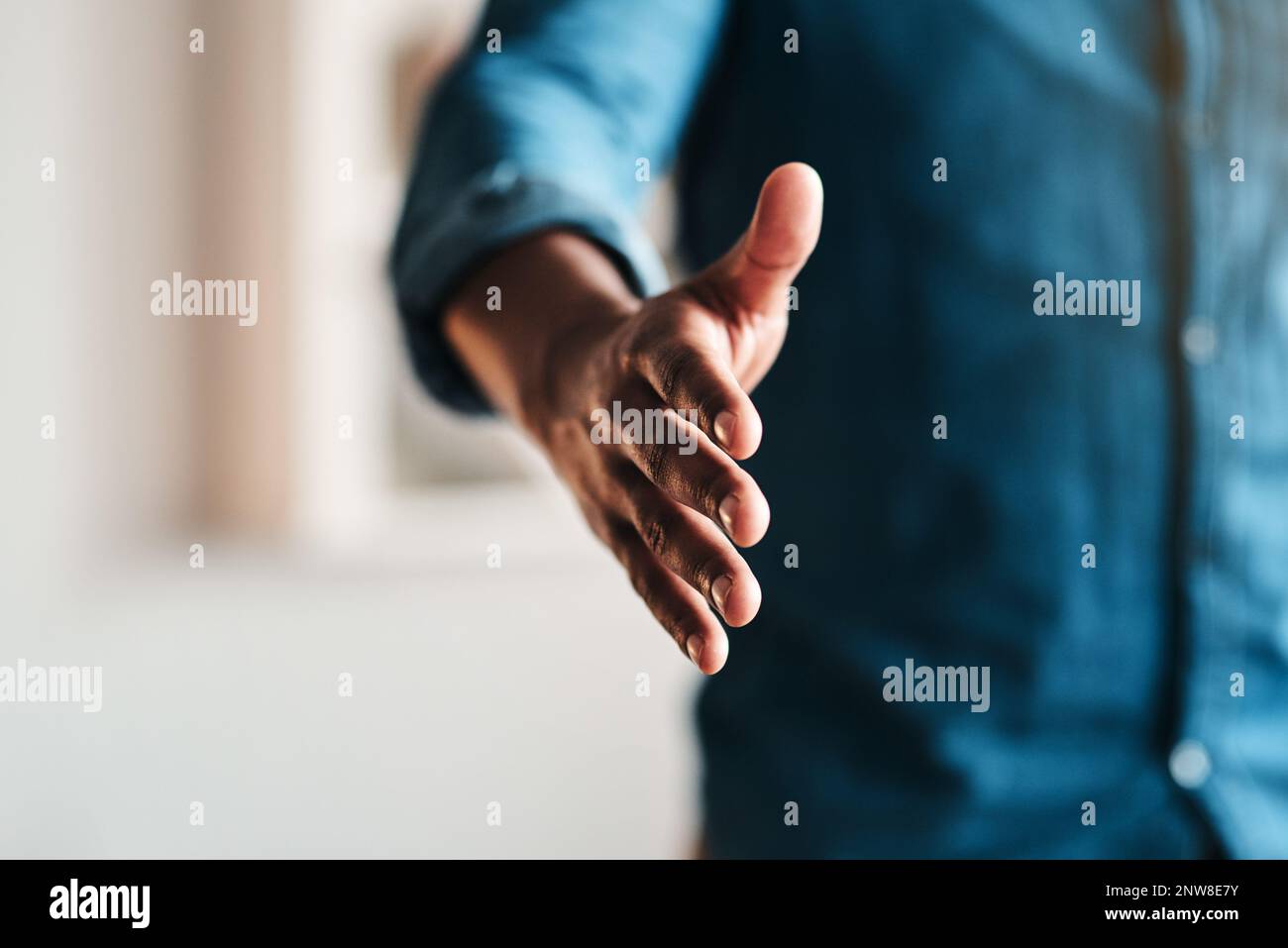 Lets seal this deal. Cropped shot of an unrecognizable businessman standing alone in his home office and extending his hand for a handshake. Stock Photo