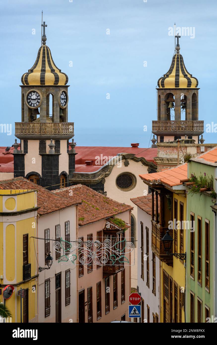 The ornate onion-shaped cupolas of Iglesia de La Concepción rise over the terracotta roofs and brightly coloured buildings of La Orotava in Tenerife. Stock Photo
