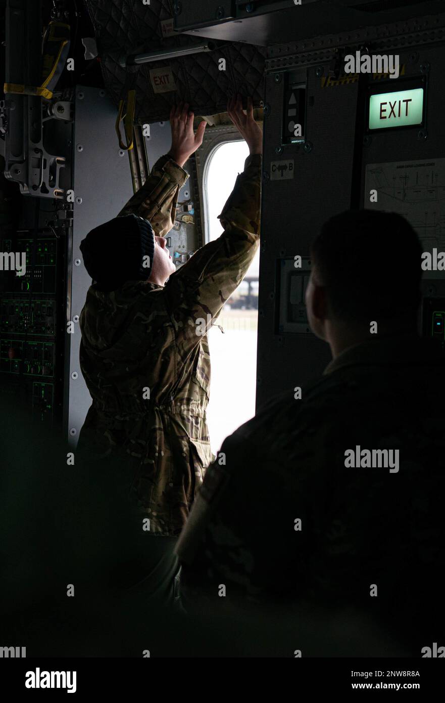 Royal air force Sgt. Tom Goulden, No. 70 Squadron air loadmaster, demonstrates how to open the exit door of a RAF Atlas C.1 A400M aircraft to U.S. service members at Ramstein Air Base, Germany, Jan. 11, 2023. The RAF teamed up with the 86th Aeromedical Evacuation Squadron for interoperability training. Stock Photo