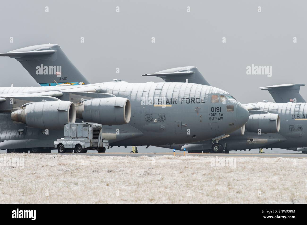 A snow-covered C-17 Globemaster III sits on the flight line at Dover ...