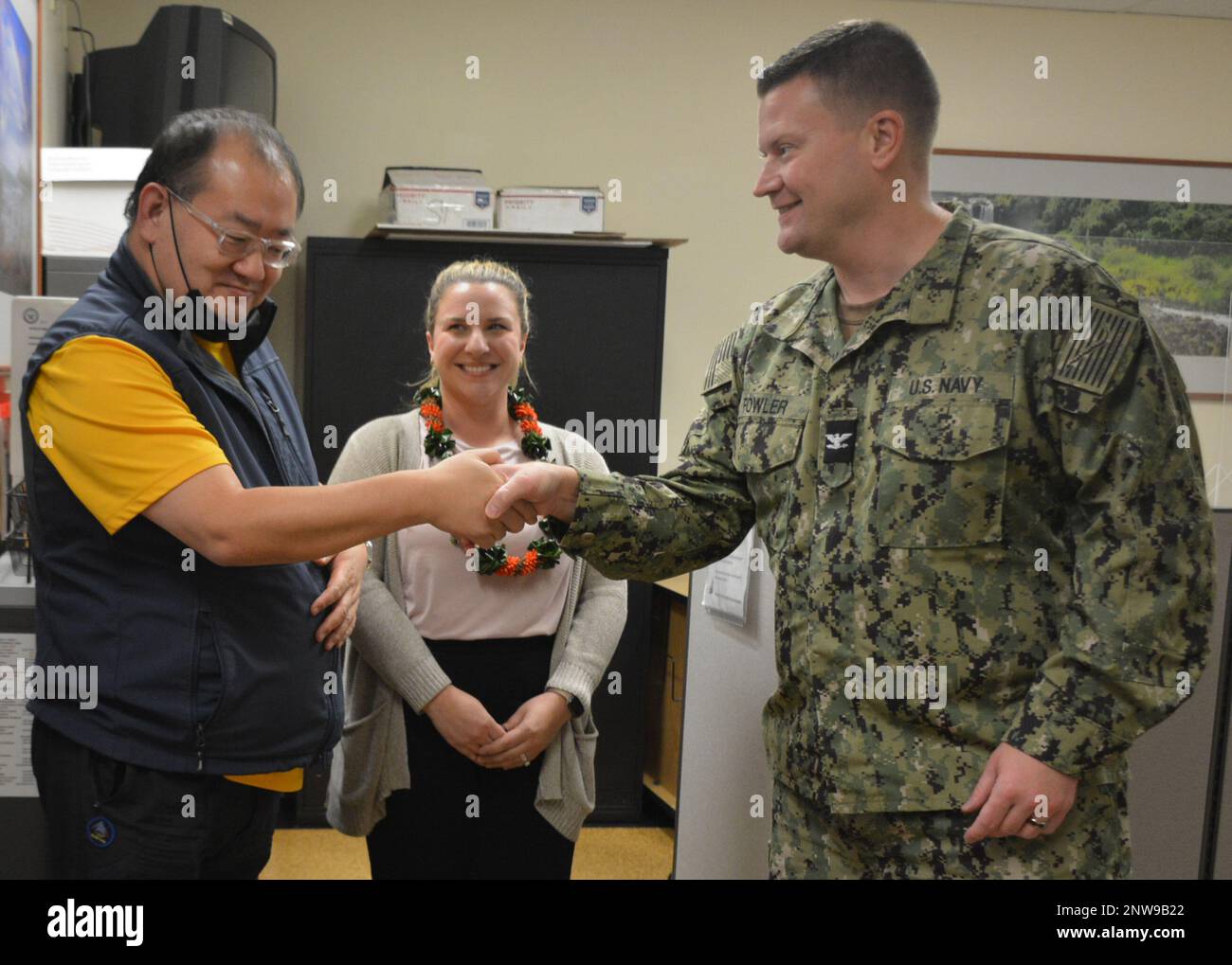 TAMC DCO Navy Capt. Ian Fowler presented Mr. Terry Lee with DCO coin for his continued assistance to staff and beneficiaries. Stock Photo