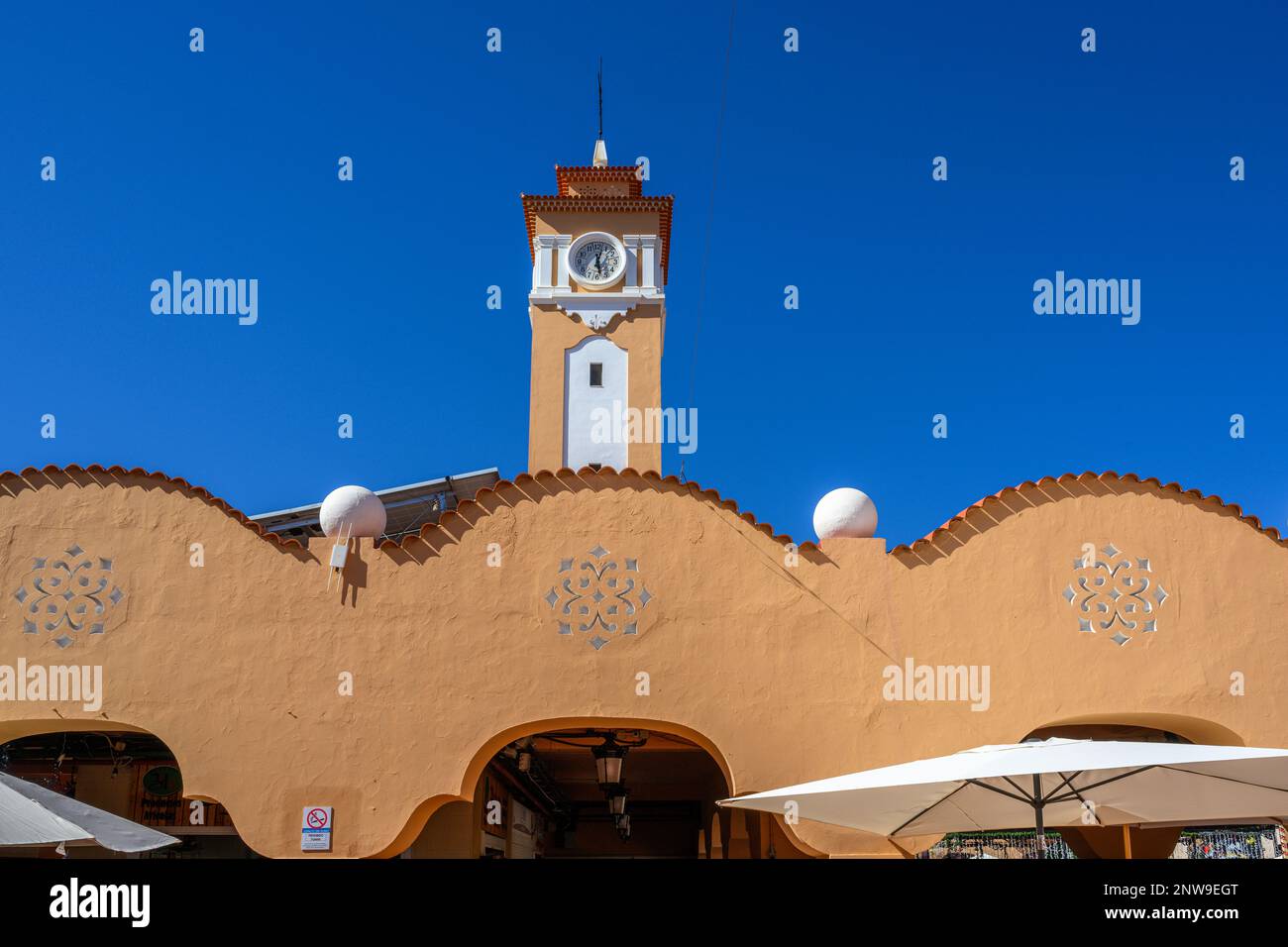 The Moorish-style clock tower rises over the ochre arches and red-tiled roof of the Mercado De Nuestra Senora De Africa in Santa Cruz de Tenerife. Stock Photo