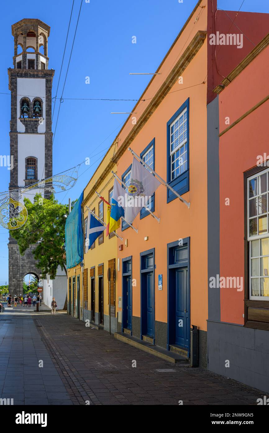 The basalt and white-washed tower of La Conception church contrasts with colourful buildings lining Calle de Antonio Dominguez Alfonso in Santa Cruz. Stock Photo