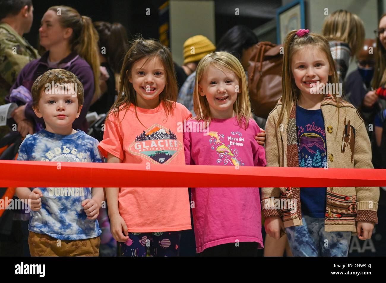 Four children wait for the ribbon to be cut during the grand reopening