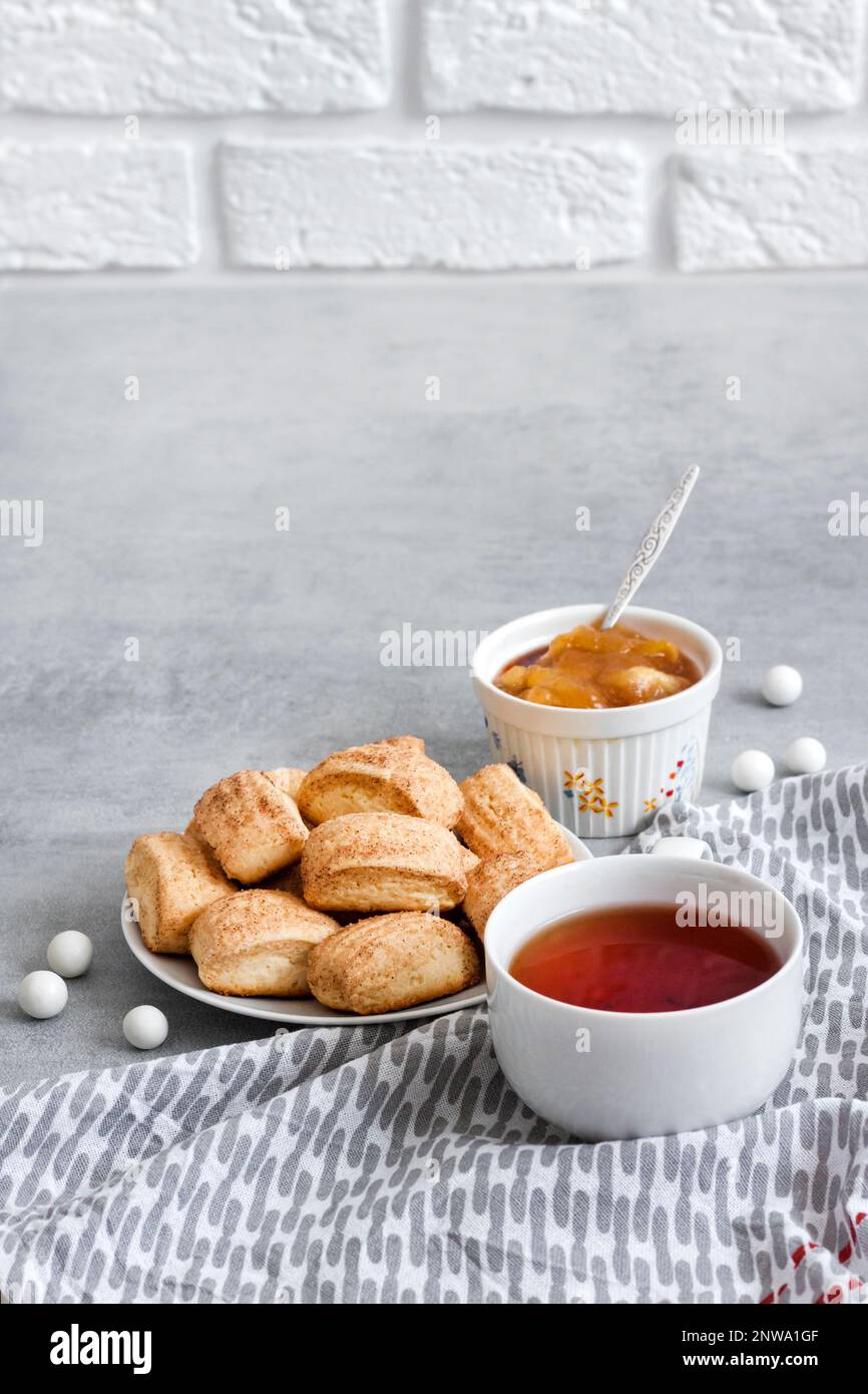 Tasty breakfast. Homemade sweet cinnamon cookies and cup of tea. Apple confiture on background. Copy space Stock Photo