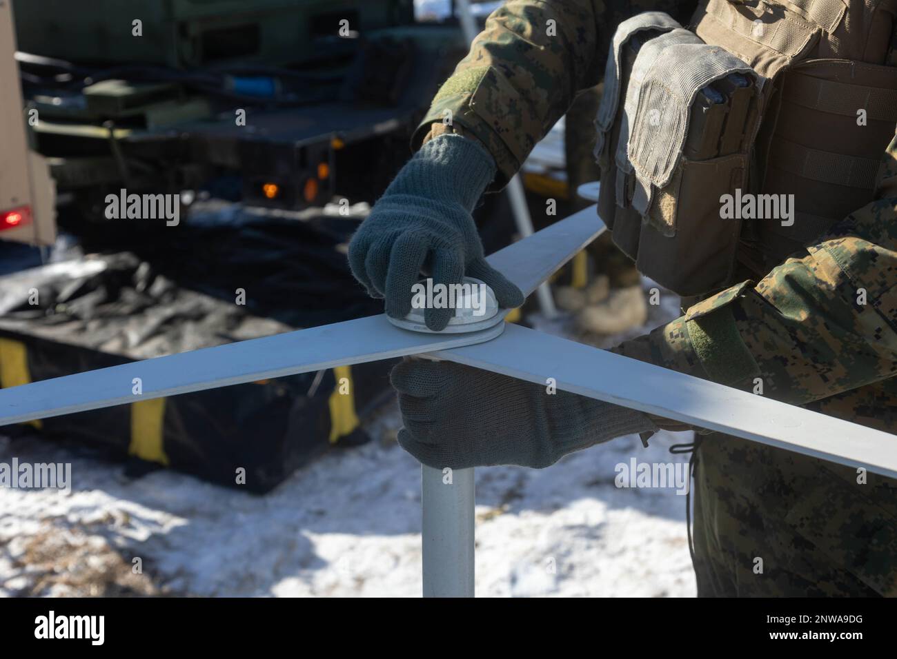 A U.S. Marine with 3d Battalion, 12th Marines assembles a pole for artic-camouflage netting during Artillery Relocation Training Program 22.4 at the Yausubetsu Maneuver Area, Hokkaido, Japan, Jan. 30, 2023. The skills developed at ARTP increase the proficiency and readiness of the only permanently forward-deployed artillery unit in the Marine Corps, enabling them to provide precision indirect fires. Stock Photo