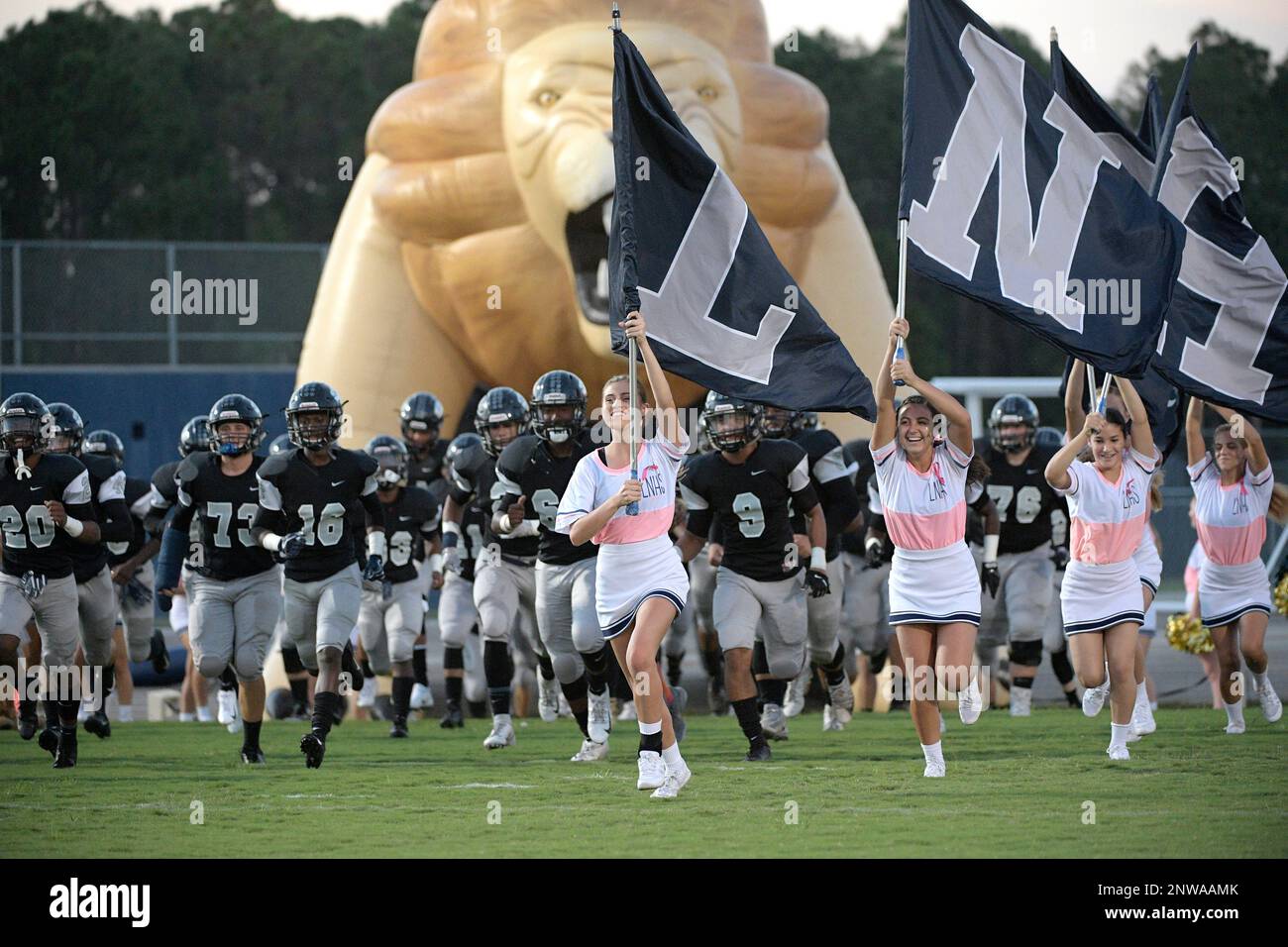 Lake Nona cheerleaders lead the team onto the field before a high
