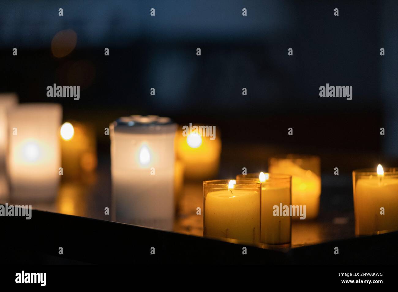 Gros plan sur des bougies jaunes et blanches dans une église Stock Photo