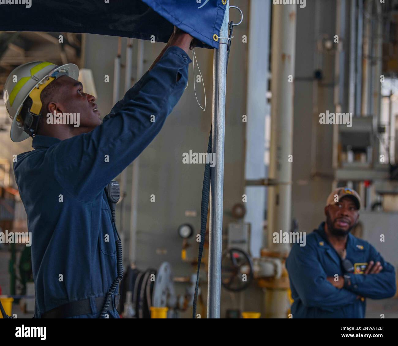 230129-N-TC338-1060  GULF OF ADEN (Jan. 29, 2023) Boatswain's Mate 3rd Class Tyler Matthews, from Chicago, left, assembles a quarterdeck while Command Senior Chief Terry Vines supervises, as the Lewis B. Puller-class expeditionary sea base USS Hershel 'Woody' Williams (ESB 4), approaches the Port of Djibouti for a scheduled visit, Jan. 29, 2023. Hershel 'Woody' Williams is on a scheduled deployment in the U.S. Naval Forces Africa area of operations, employed by U.S. Sixth Fleet to defend U.S., Allied and partner interests. Stock Photo