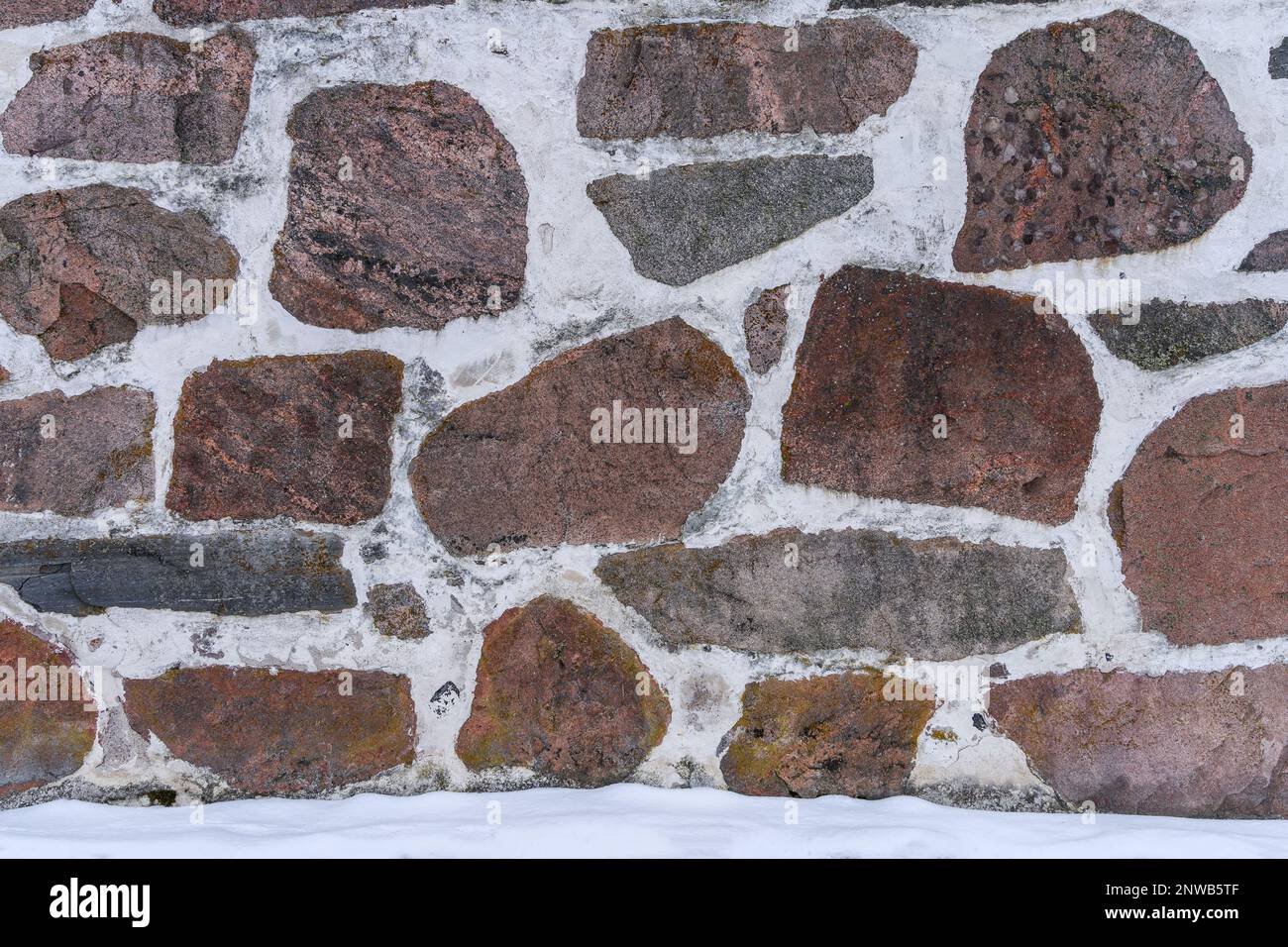 Medieval stone wall background texture in winter. Stock Photo