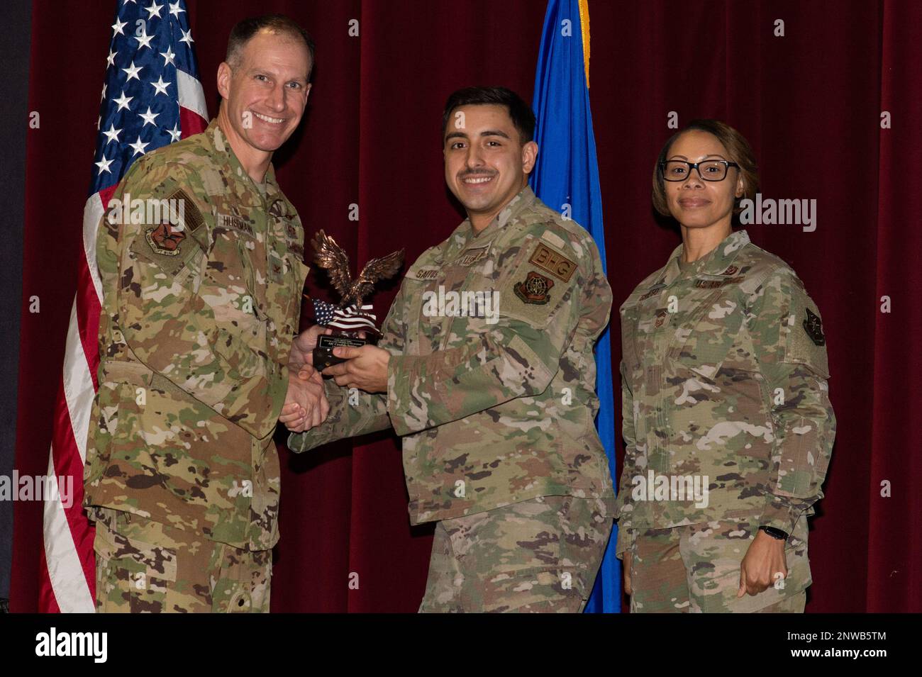 Col. Matt Husemann, left, 436th Airlift Wing commander and Chief Master Sgt. Tiffany Griego, right, 436th Mission Support Group senior enlisted leader, present Airman 1st Class Candido Santos, center, 436th Logistics Readiness Squadron, with a trophy during the 436th AW 4th Quarter Awards ceremony held at the Base Theater on Dover Air Force Base, Delaware, Jan. 26, 2023. Santos was recognized as the wing’s Honor Guard Member of the Quarter. Stock Photo